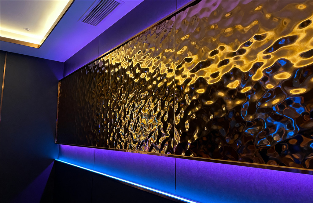 Water ripple stainless steel feature wall behind a modern gray sofa in a luxury living space